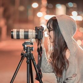 Une femme devant son appareil photo, l'oeil dans l'objectif